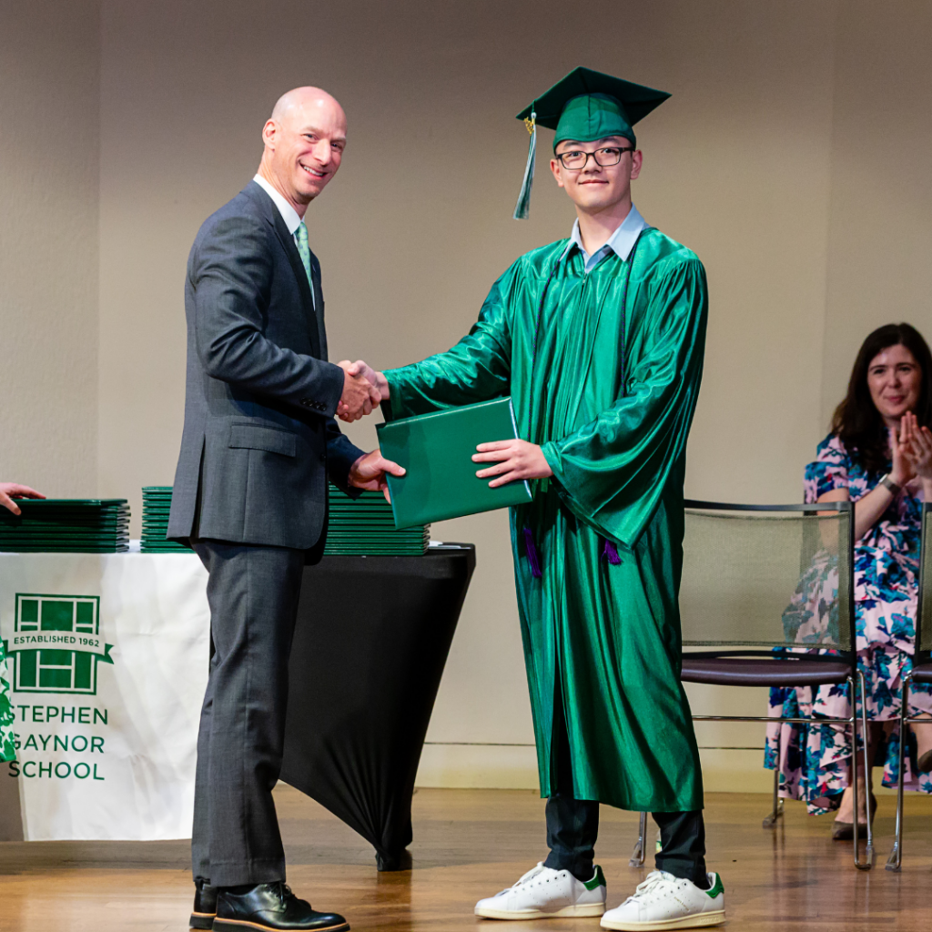 Dr. Gaynor shakes hands with a graduate on stage