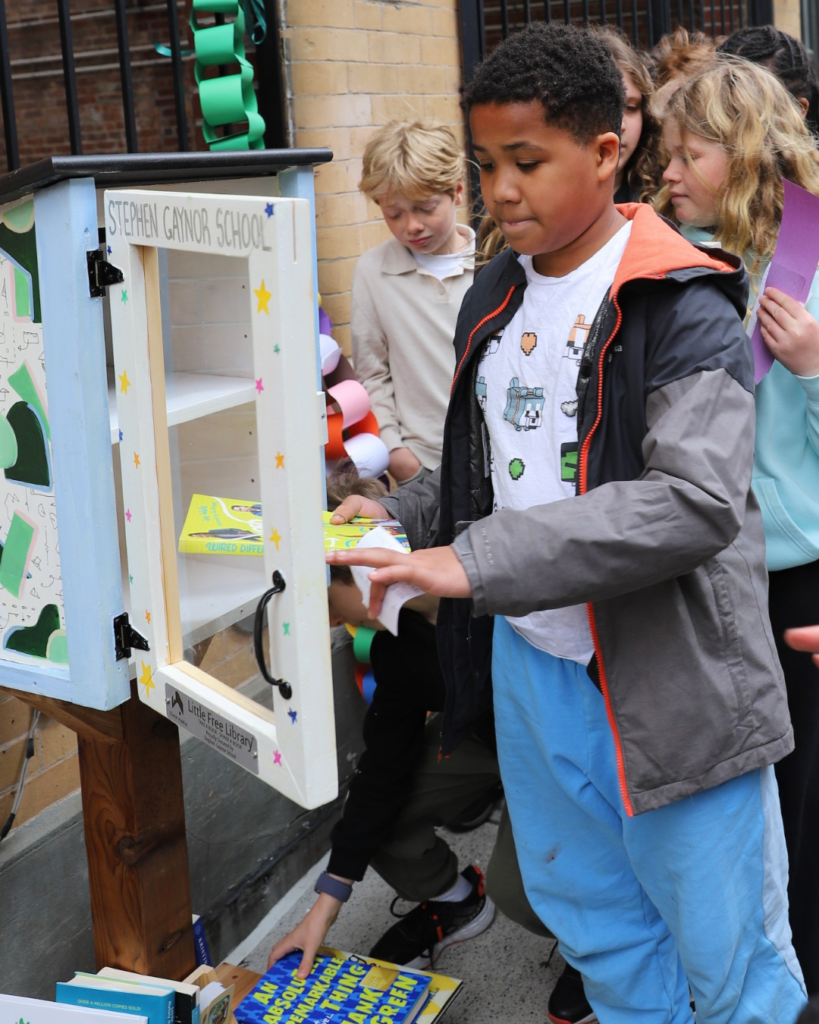 Students stocking the Little Free Library with the first selection of books.